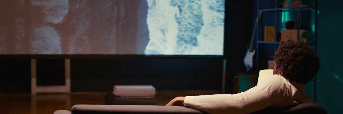 adult relaxing at home watching a movie with projector